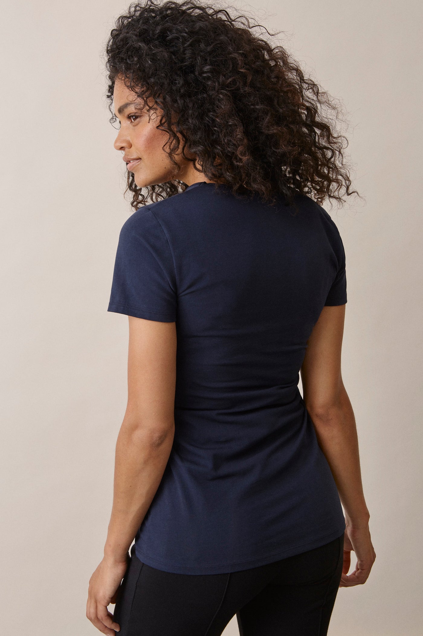Femme de dos portant le t-shirt Le Classique manches courtes de grossesse et d'allaitement en coton bio certifié GOTS, coloris marine.